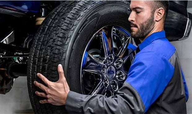 A Technician fitting a tire into vehicle