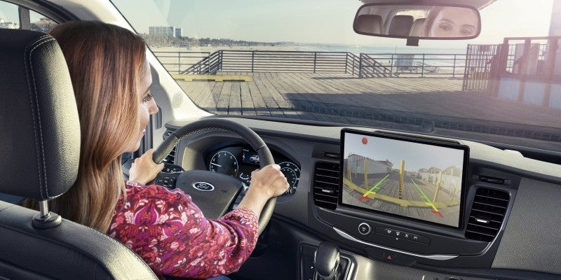 A woman driving a 2025 Ford Transit